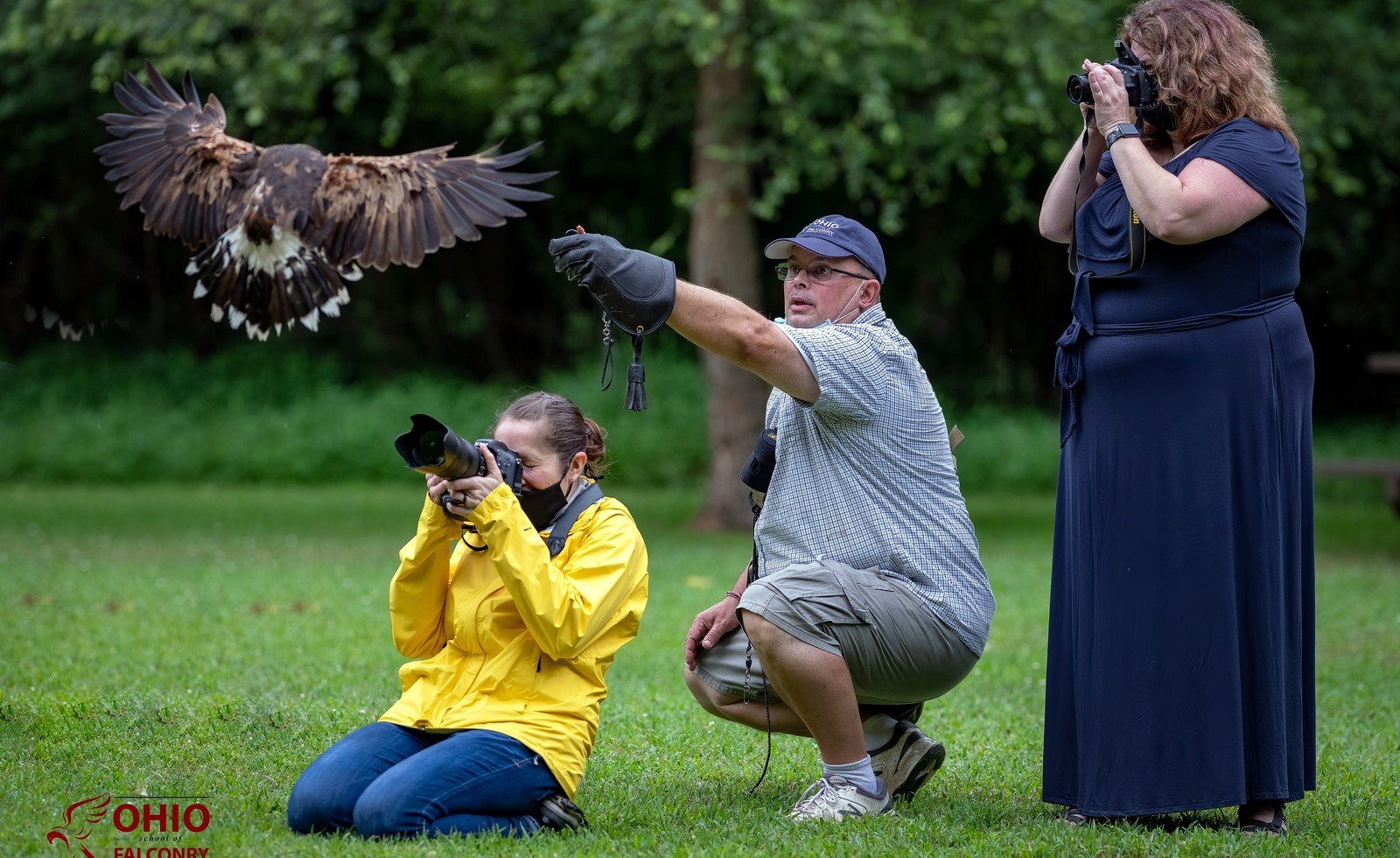 Guests walking through woods with hawks on gloves